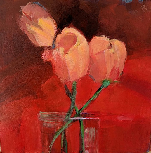 salmon pink tulips in vase on red background